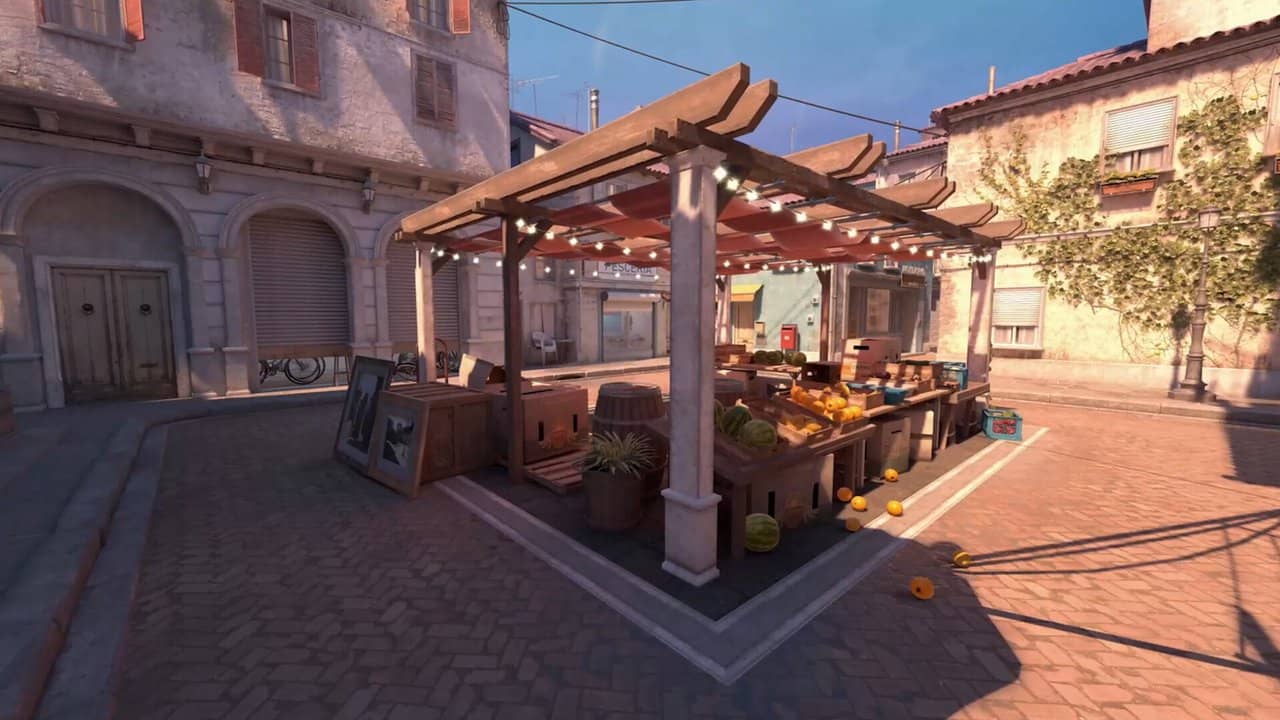 Counter-Strike 2'de Akdeniz tarzı bir haritada ahşap çardaklı avlu ve taş evler