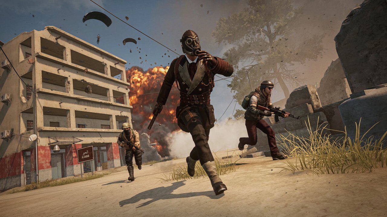 PUBG: Battlegrounds'ta binaların arasında koşan iki oyuncu ve gökyüzünde paraşütler